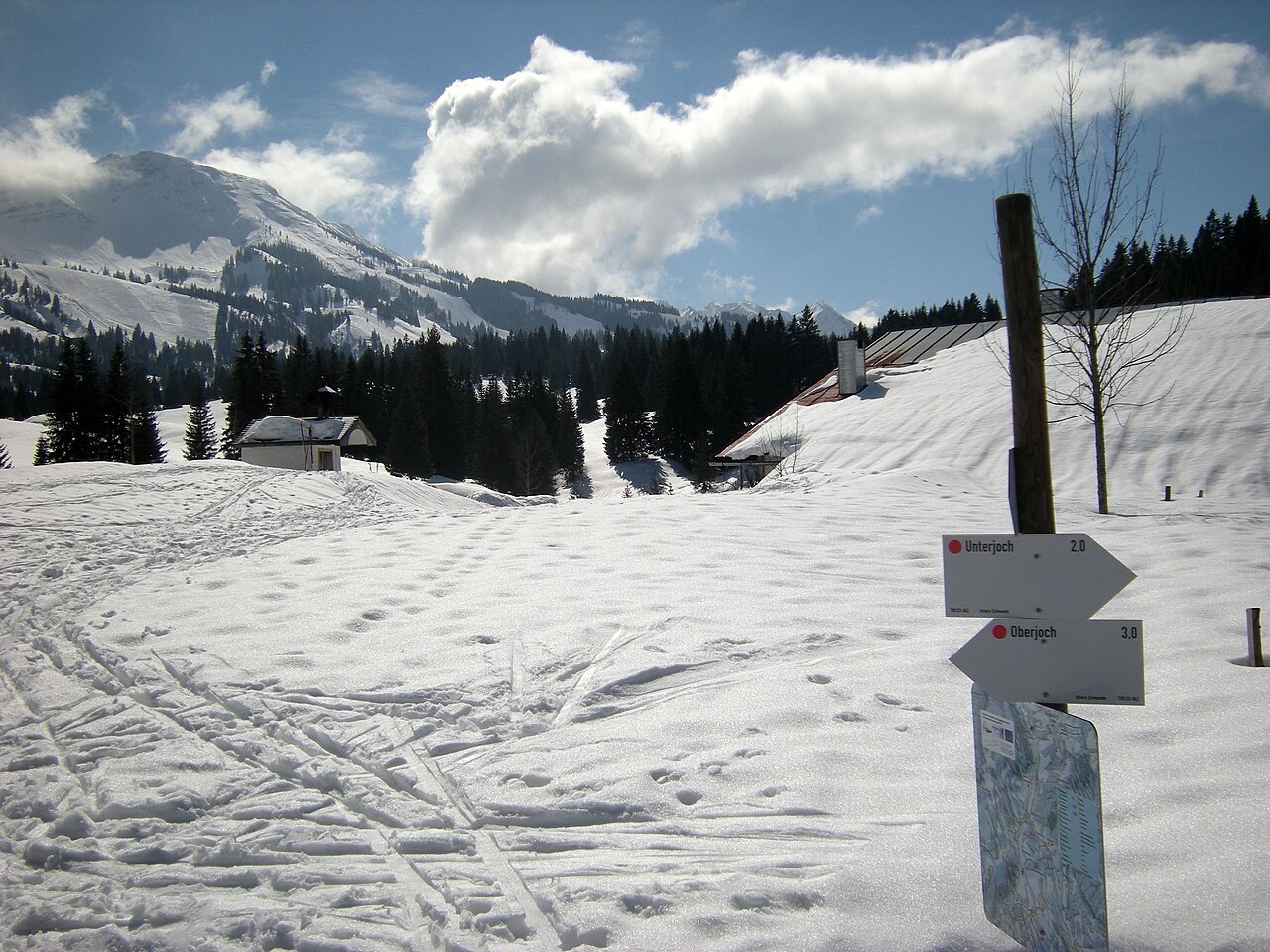 Verschneite Loipe mit Wegweiser in Oberjoch im Winter