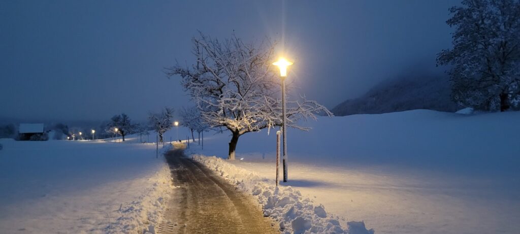 Beleuchteter Winterweg am Abend in Bad Hindelang