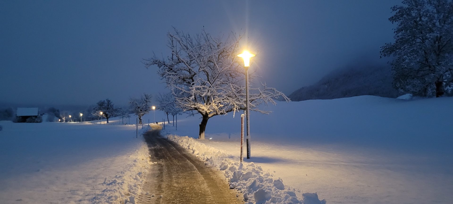 Beleuchteter Winterweg am Abend in Bad Hindelang