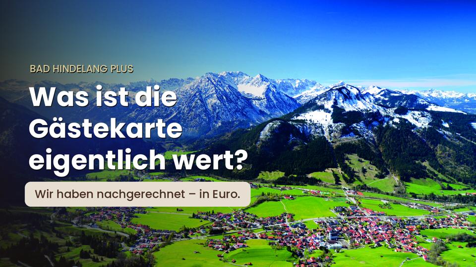 Luftbild von Bad Hindelang im Ostrachtal vor den Allgäuer Alpen mit dem Text: Bad Hindelang PLUS – Was ist die Gästekarte eigentlich wert? Wir haben nachgerechnet – in Euro.