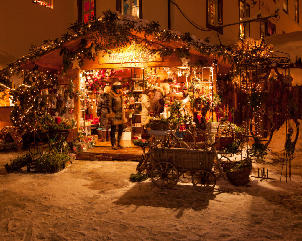 Geschmückte, warm beleuchtete Holzhütte auf dem Erlebnis-Weihnachtsmarkt Bad Hindelang