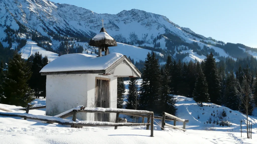 Verschneite Untere Alpe Schwand mit Kapelle bei Bad Hindelang im Winter