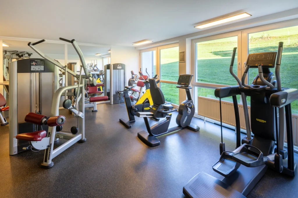 Fitnessraum mit Geräten und Fensterfront im Hotel DIE GAMS