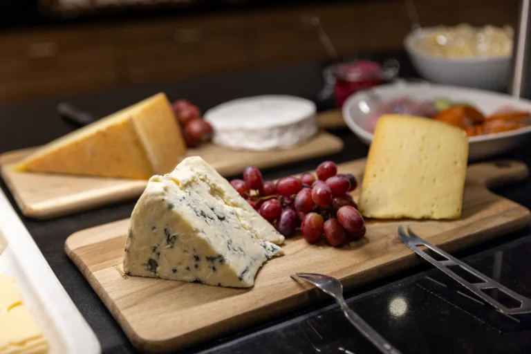 Käsebrett mit Bergkäse, Blauschimmelkäse und Trauben am Frühstücksbuffet