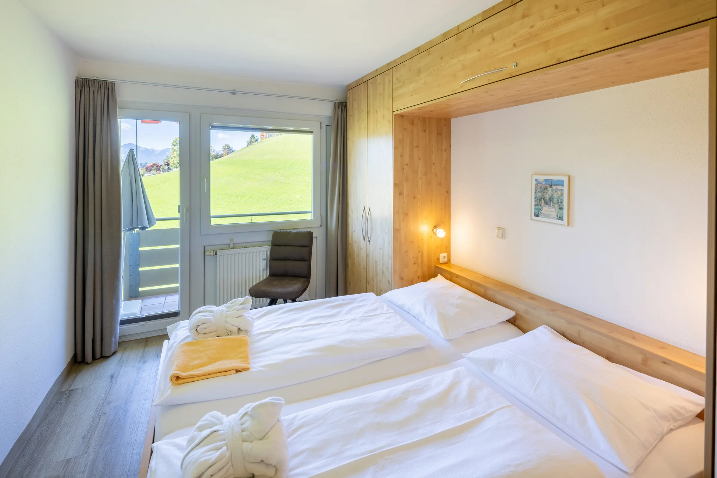 Bedroom with double bed and balcony door in a Premium apartment